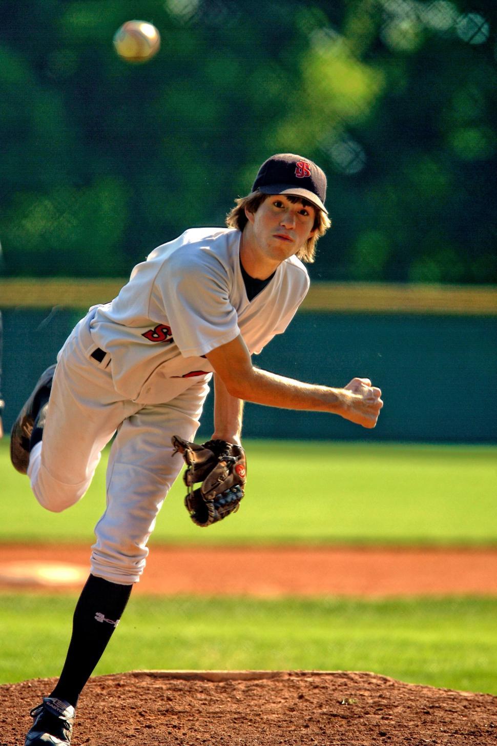 Free Image of Baseball Player Pitching a Ball on Top of a Field 
