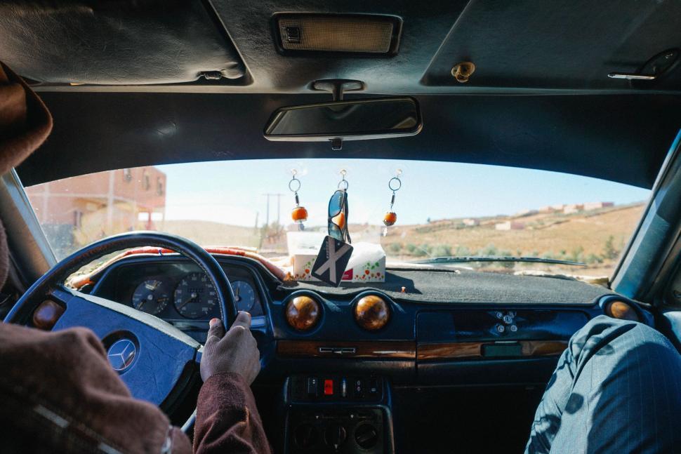Free Image of Person Sitting in Car With Feet on Steering Wheel 