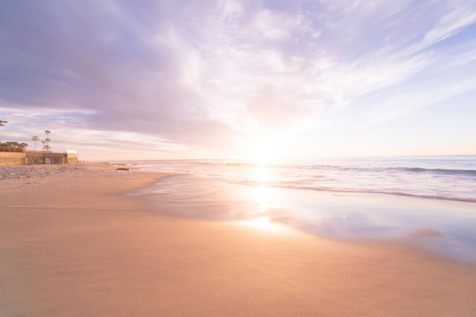 Free Image of Sun Setting on Beach With Ocean Background 