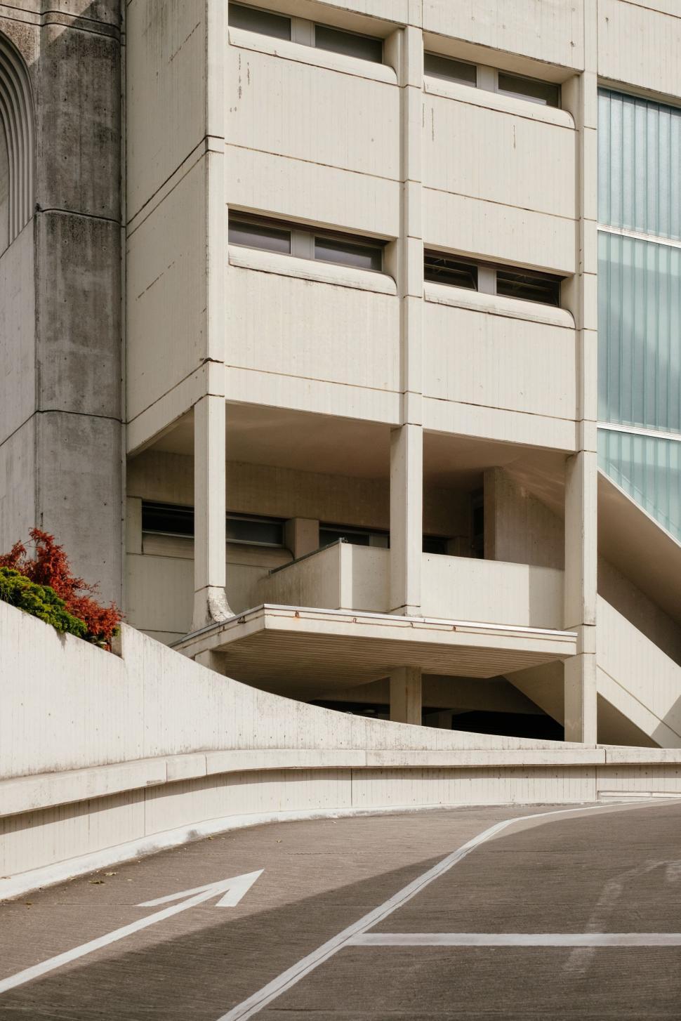 Free Image of Man Skateboarding Down Street Next to Tall Building 