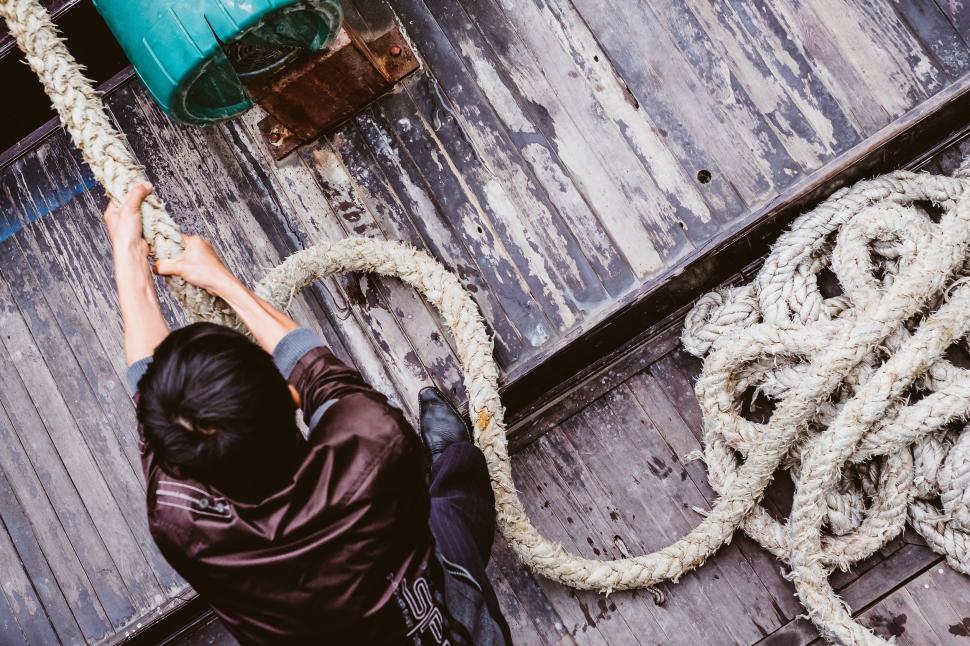 Free Image of Man Climbing Up Side of Boat 