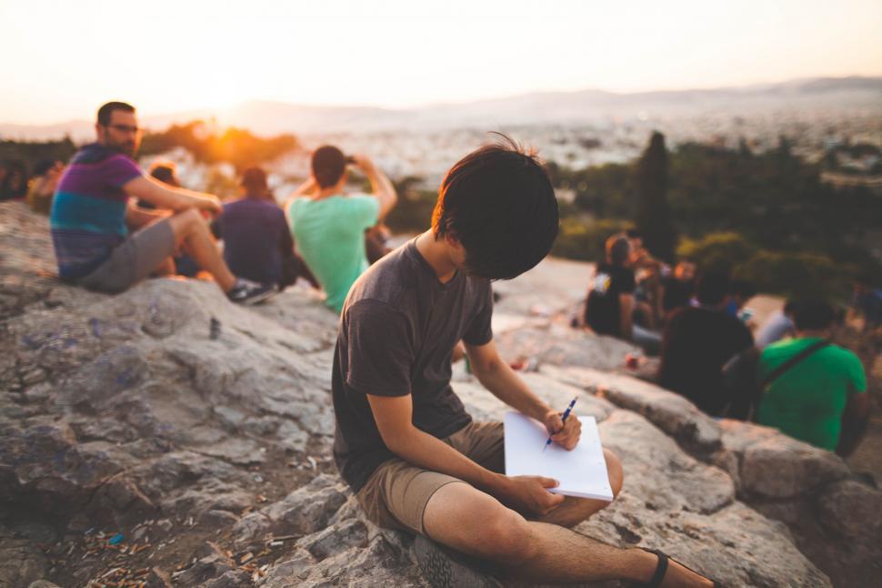 Free Image of Group of People Sitting on Top of Rocky Hillside 