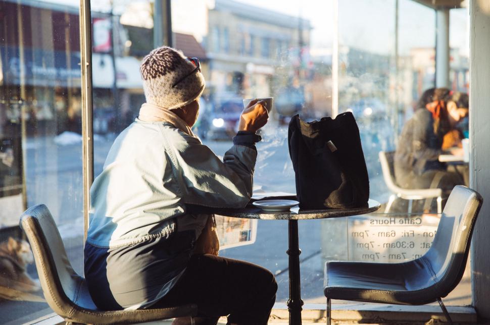 Free Image of Man Sitting at Table in Front of Window 