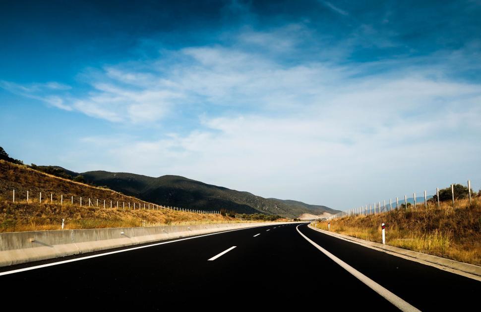Free Image of Empty Road With Fence Alongside 