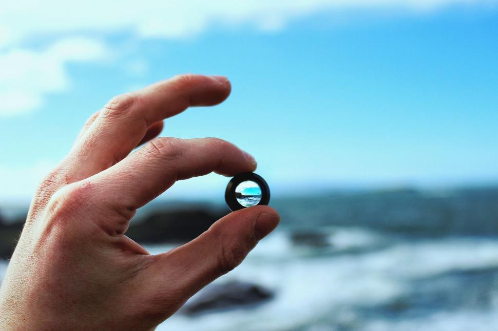 Free Image of Hand Holding Object by Body of Water 