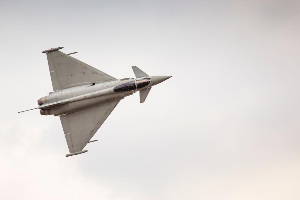 Free Image of Fighter Jet Flying Through Cloudy Sky 
