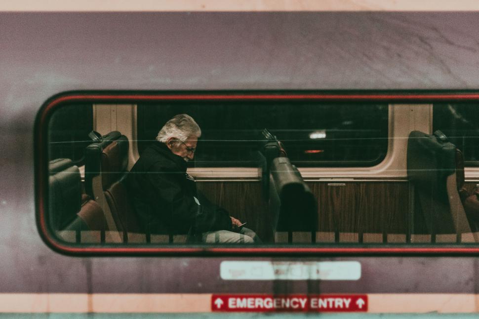 Free Image of Man Sitting on Train, Looking Out Window 