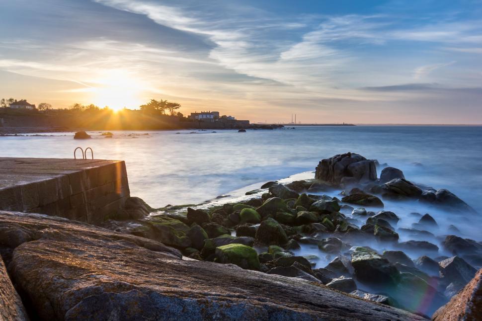 Free Image of Sun Setting Over Ocean and Rocks 
