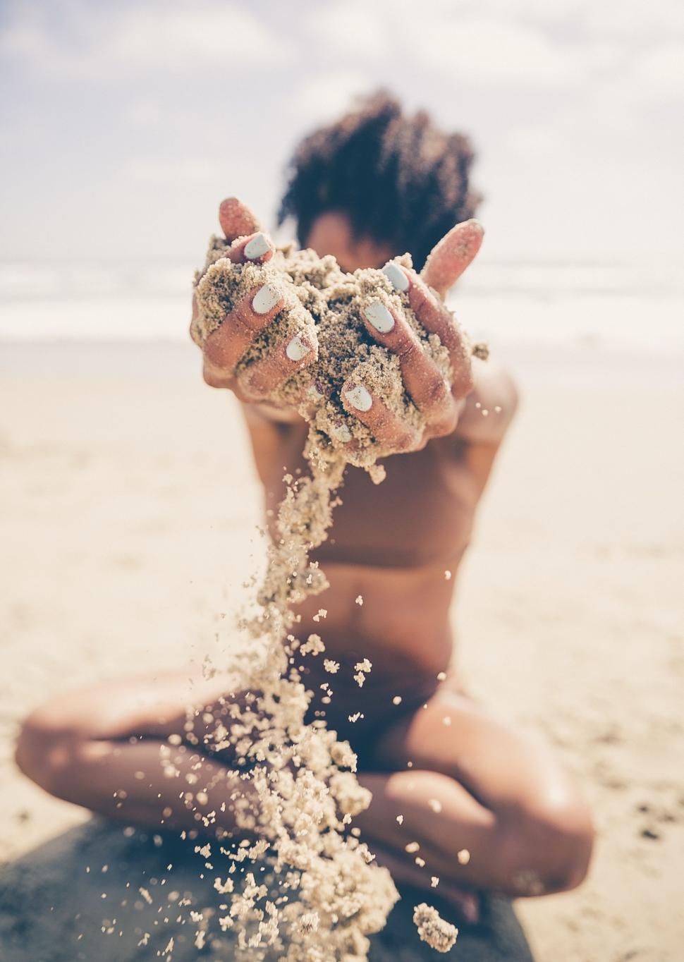 Free Image of Man Sitting on Top of Beach Covered in Sand 