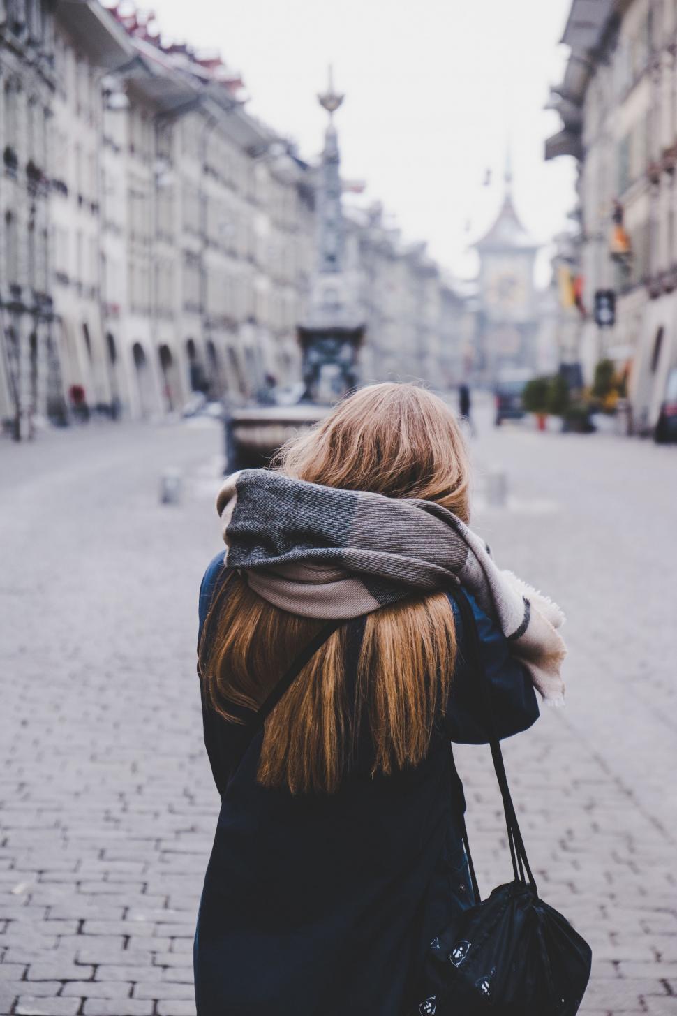 Free Image of Woman Walking Down Street With Scarf on Head 