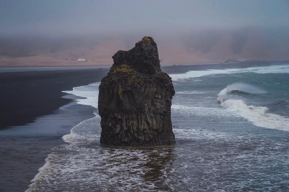 Free Image of Large Rock Protruding From Ocean 