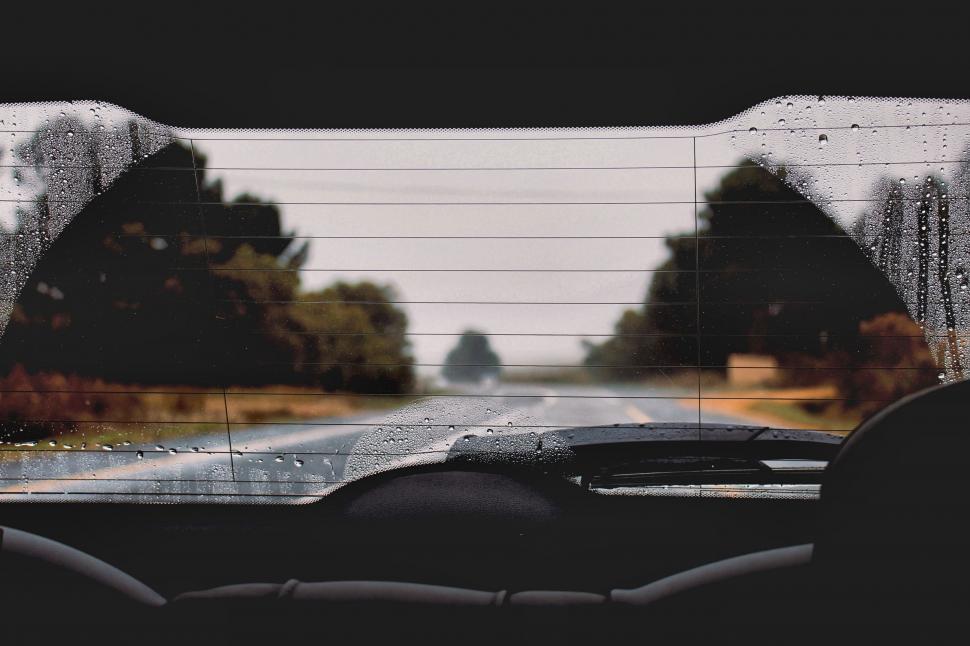 Free Image of Car Driving Down Road Next to Forest 