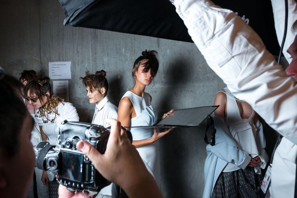 Free Image of Group of People Standing Around a Camera 