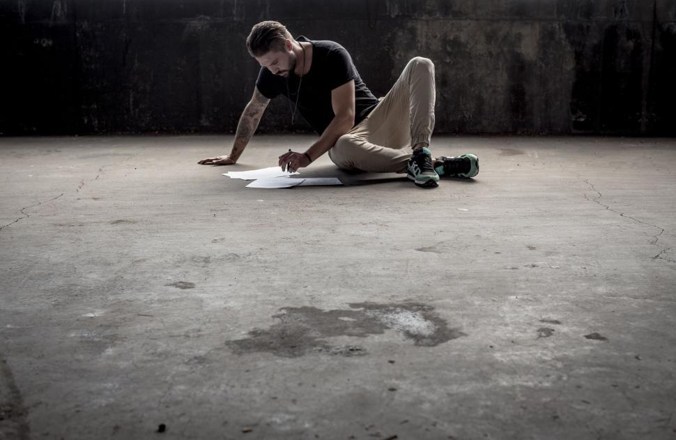 Free Image of Man Laying on Ground With Skateboard 