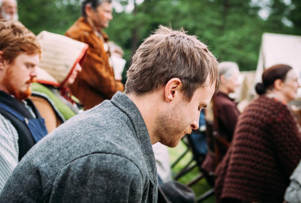 Free Image of Group of People Sitting on Top of Grass Covered Field 