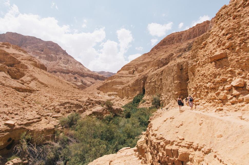 Free Image of Group of People Walking Down a Dirt Road 