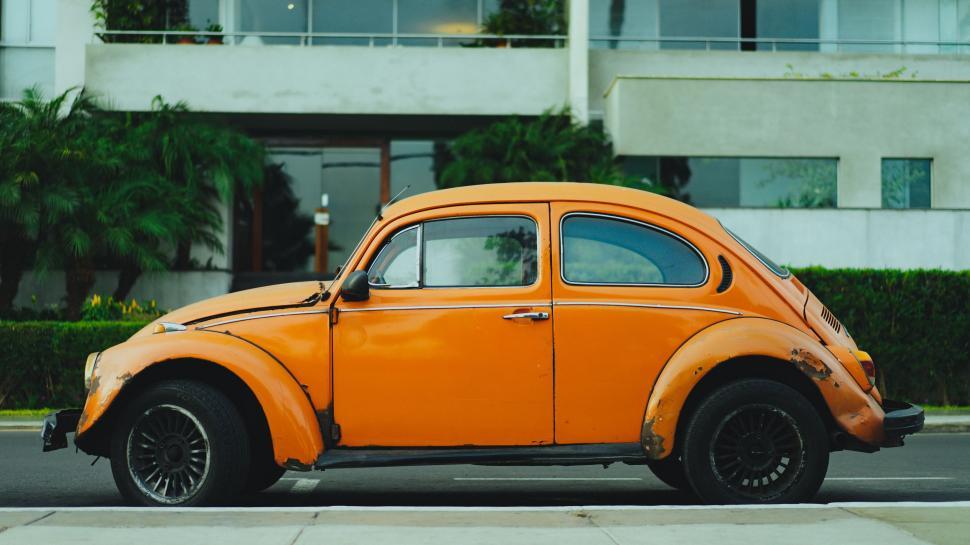 Free Image of Orange Car Parked Along Roadside 