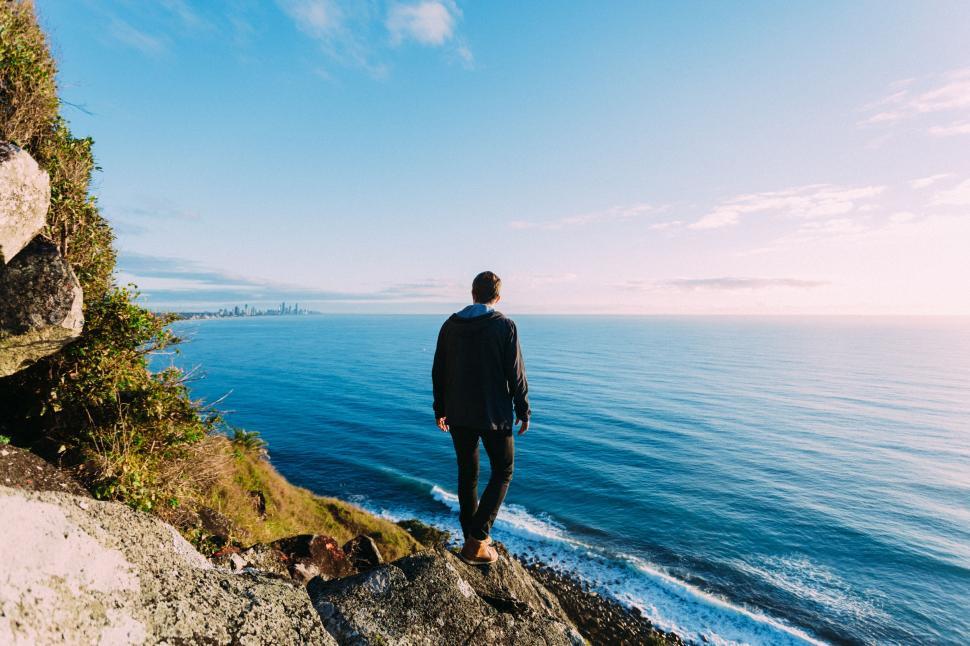 Free Image of Man Standing on Cliff Overlooking Ocean 
