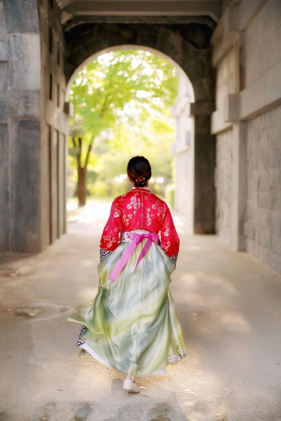Free Image of Woman in Long Dress Walking Through Tunnel 