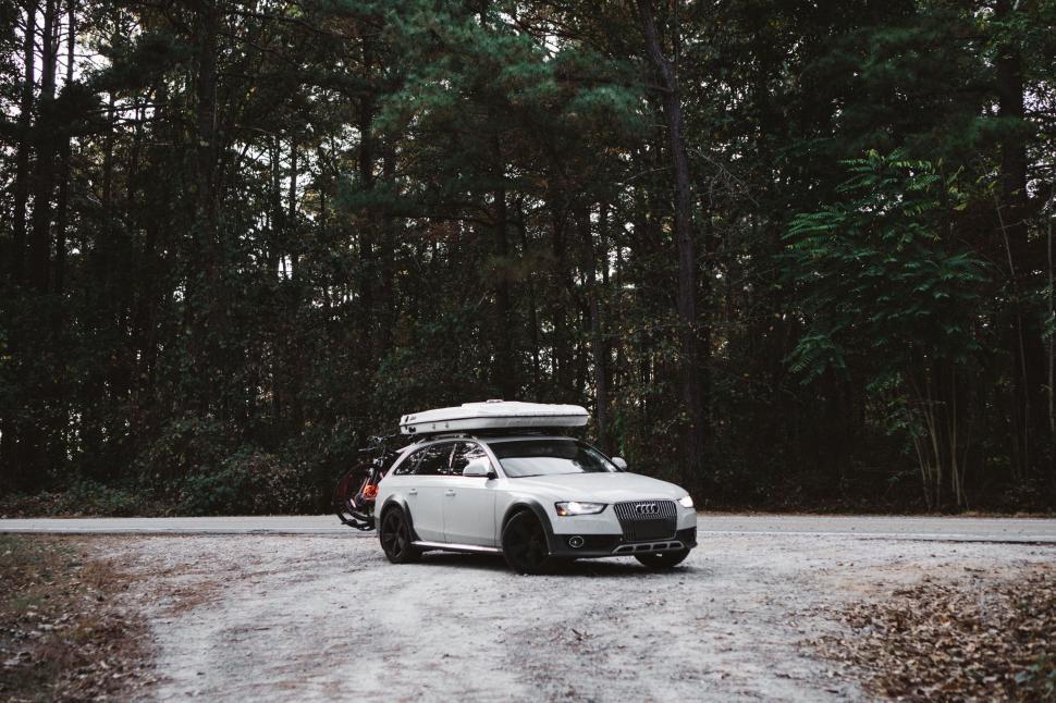 Free Image of White Car With Surfboard on Top 