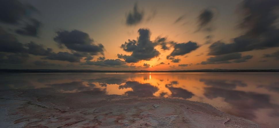 Free Image of The Sun Setting Over a Vast Lake 