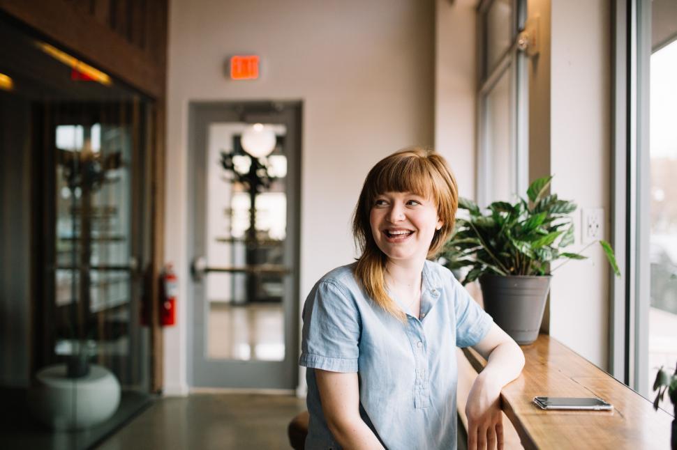 Free Image of Woman Sitting at Table in Front of Window 