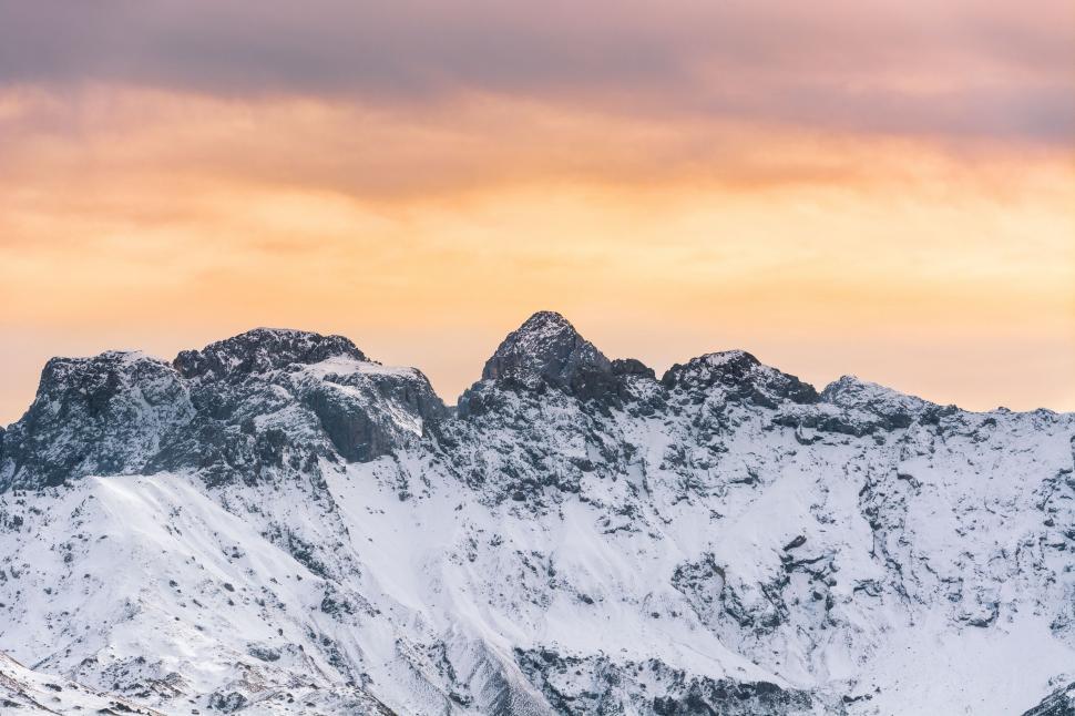 Free Image of Snow Covered Mountain Range Under Cloudy Sky 