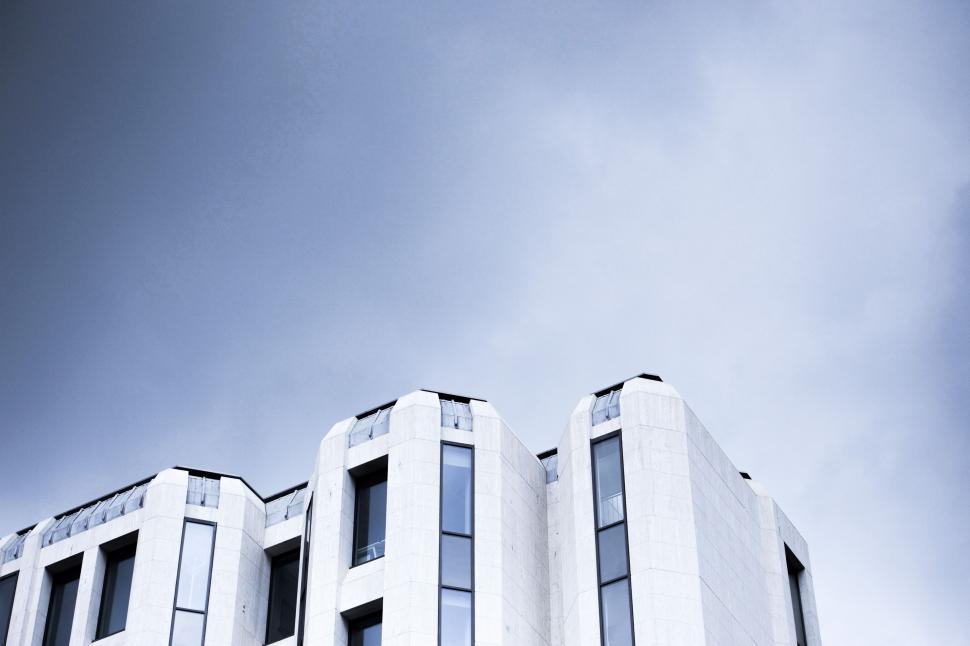 Free Image of Tall White Building Under Cloudy Sky 