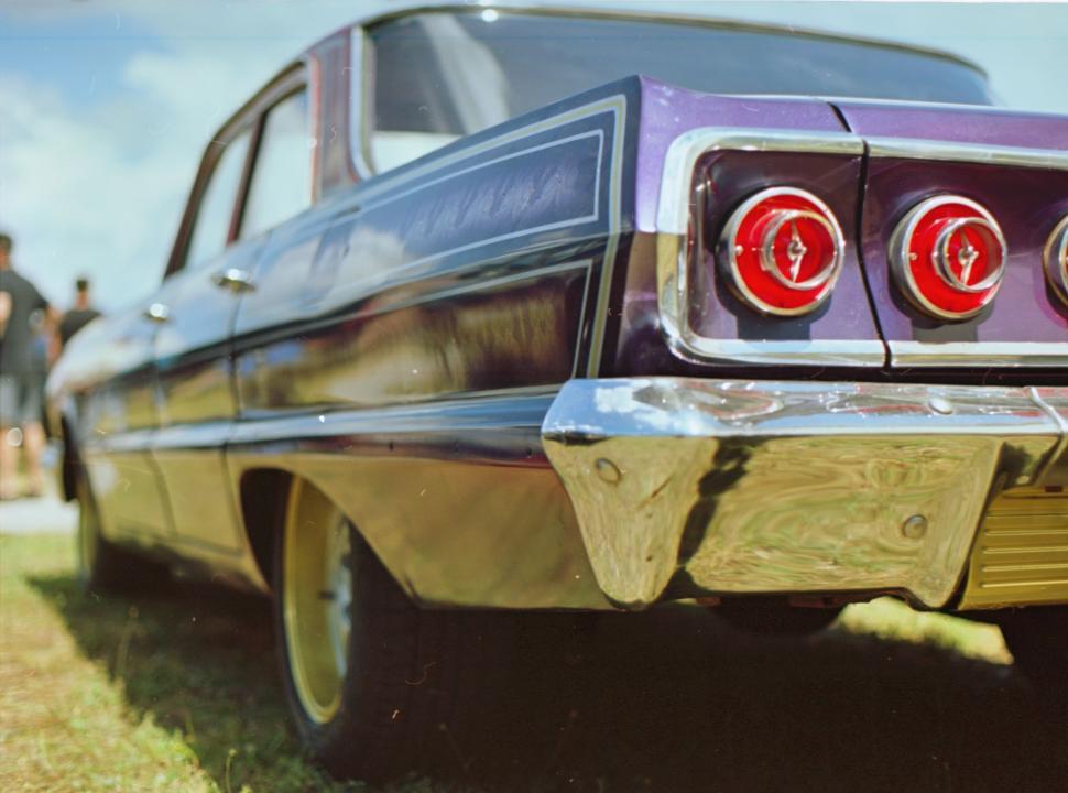 Free Image of Purple Car Parked on Grass-Covered Field 