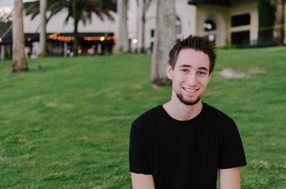 Free Image of Man Relaxing in Grass in Front of Building 