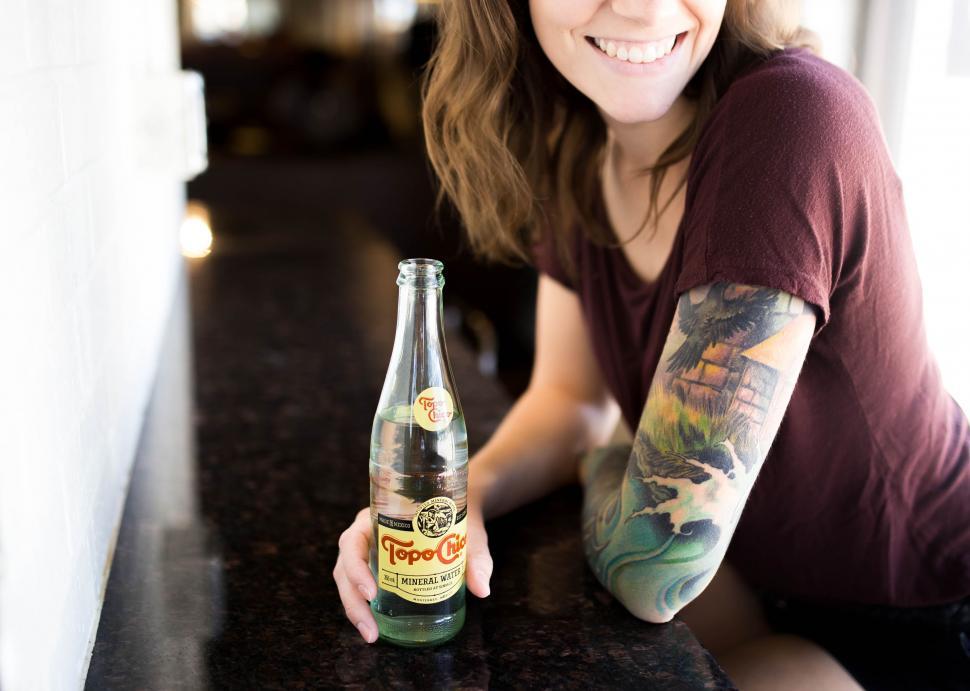 Free Image of Woman Sitting at Table With Beer Bottle 