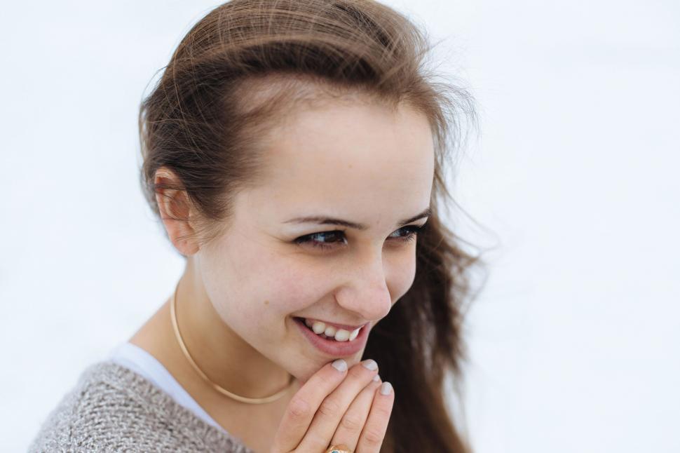 Free Image of Smiling Woman Holding Hands Together 