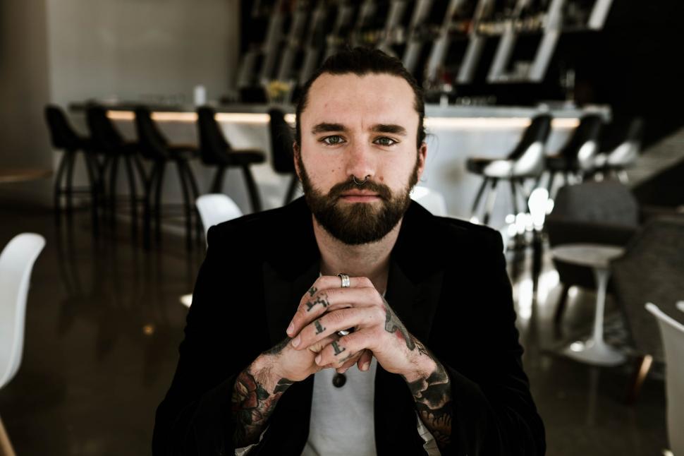 Free Image of Bearded Man Sitting in Front of Table 
