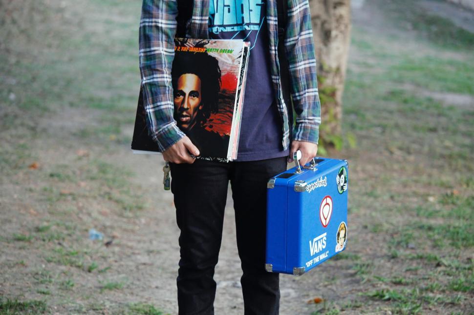 Free Image of Man Holding Blue Suitcase on Dirt Road 