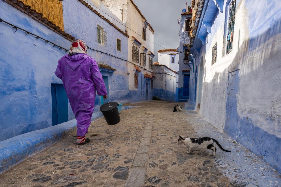 Free Image of Person in Purple Outfit Walking Down Street 