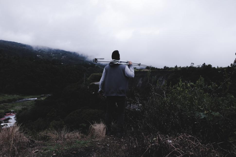 Free Image of Person Walking Through Field Carrying Surfboard 