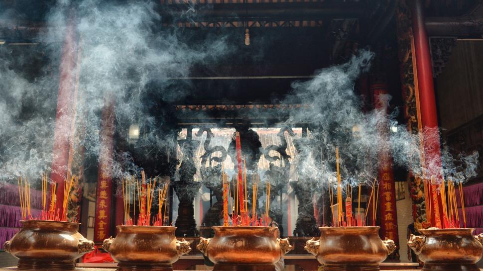Free Image of Group of People Standing in Front of Smoking Pots 