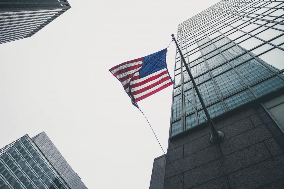 Free Image of American Flag Flying in Front of Tall Building 