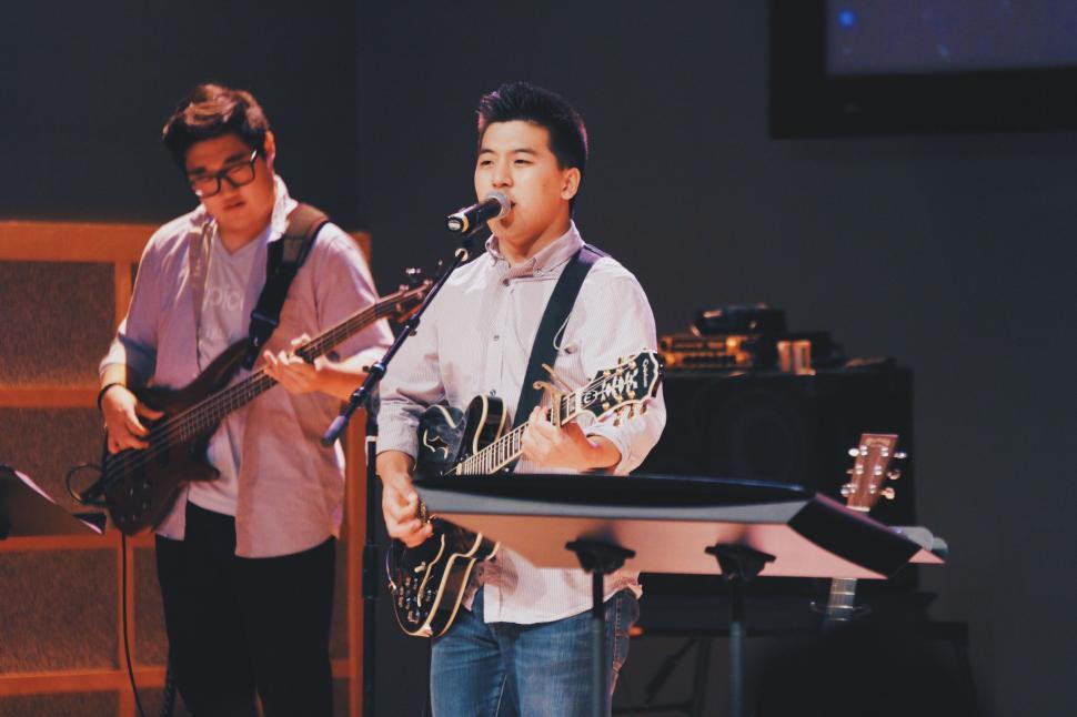 Free Image of Man Playing Guitar and Singing Into Microphone 