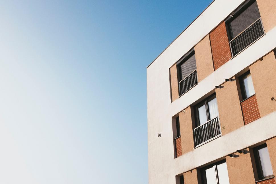 Free Image of Tall Building With Windows and Balconies Against Blue Sky 