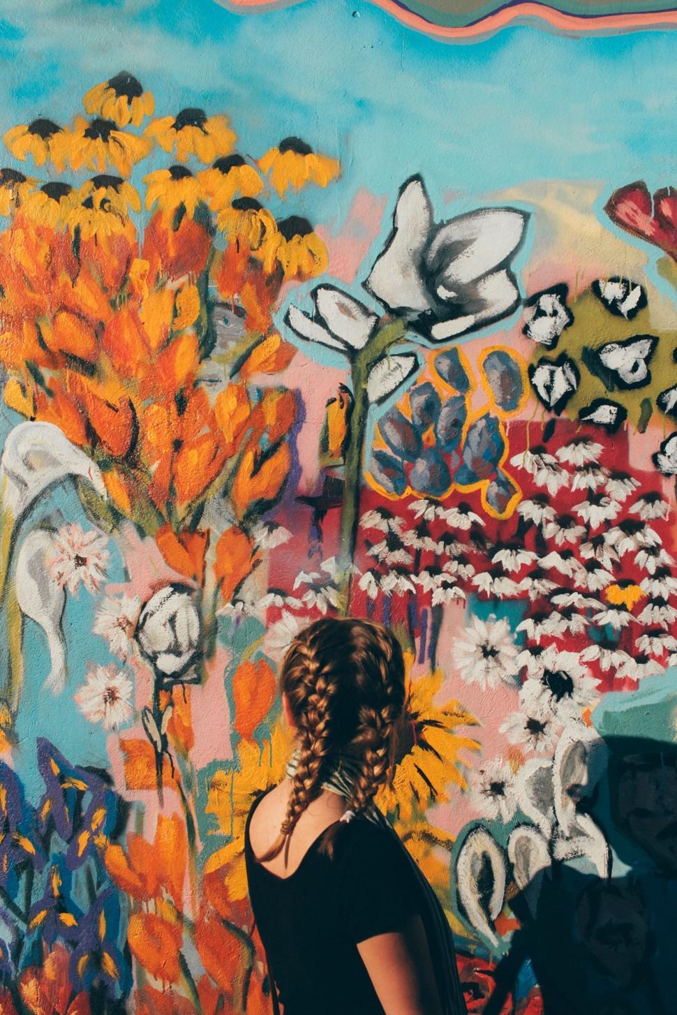 Free Image of Woman Standing in Front of Colorful Wall 