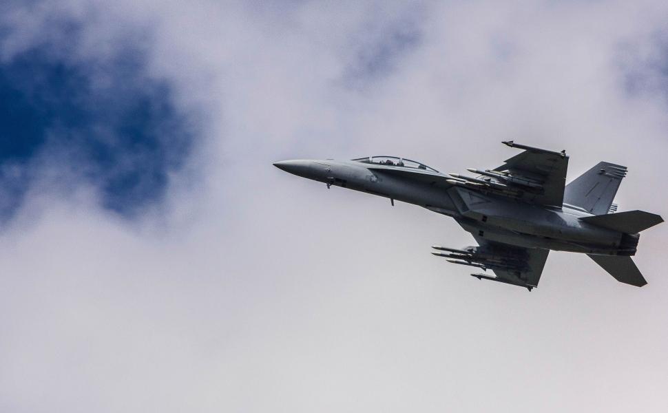Free Image of Fighter Jet Flying Through Cloudy Blue Sky 