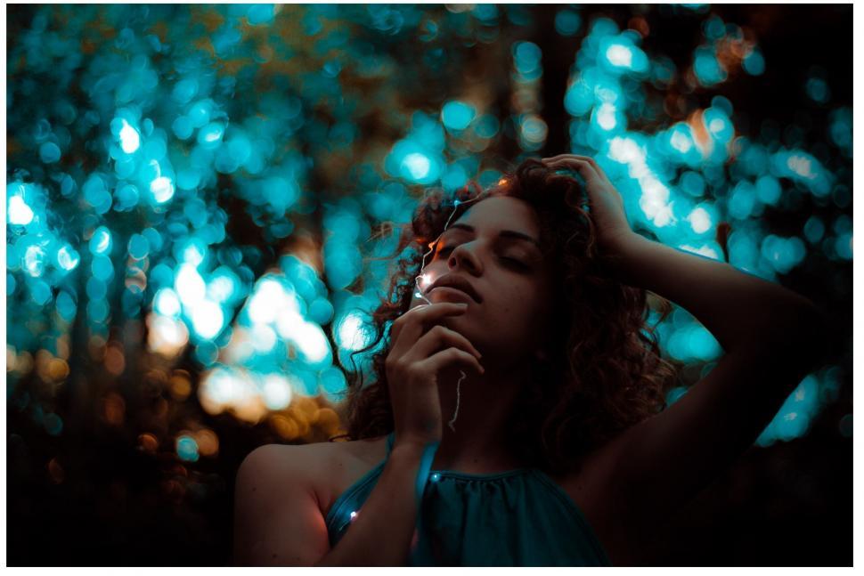 Free Image of Woman in Blue Dress Holding Head in Hands 