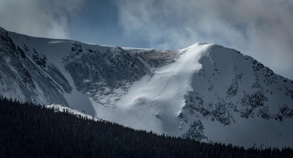 Free Image of Snow-Covered Mountain Under Cloudy Sky 