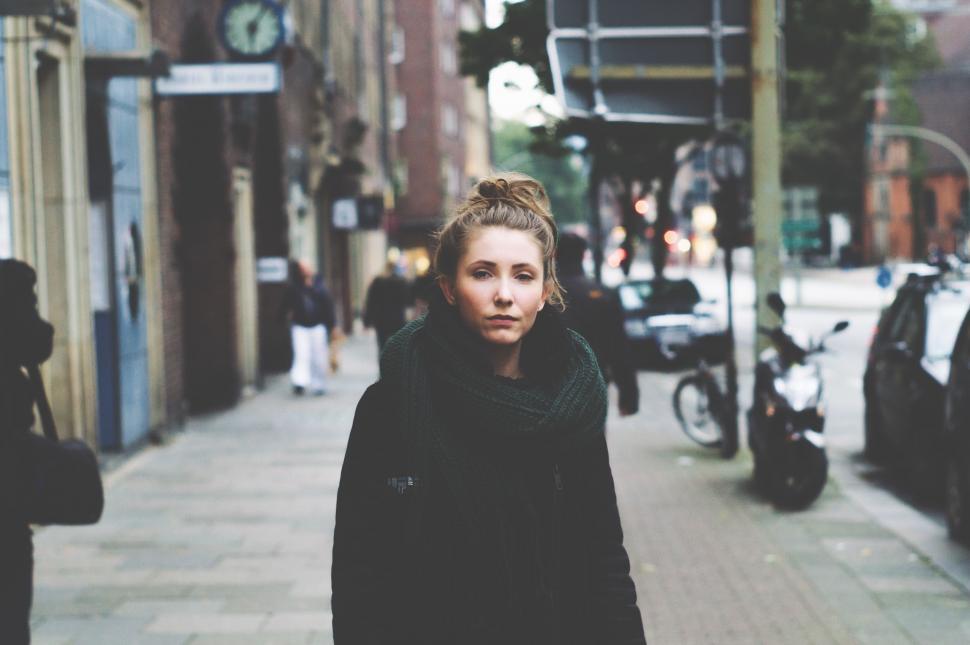 Free Image of Woman Walking Down Street Next to Parked Cars 