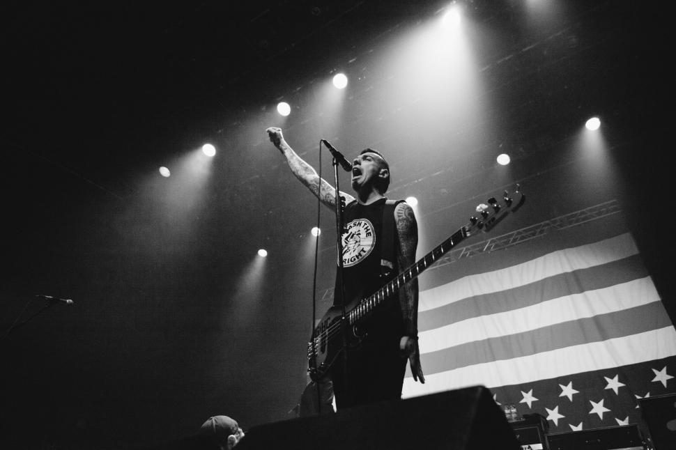 Free Image of Man Standing on Stage With Guitar 