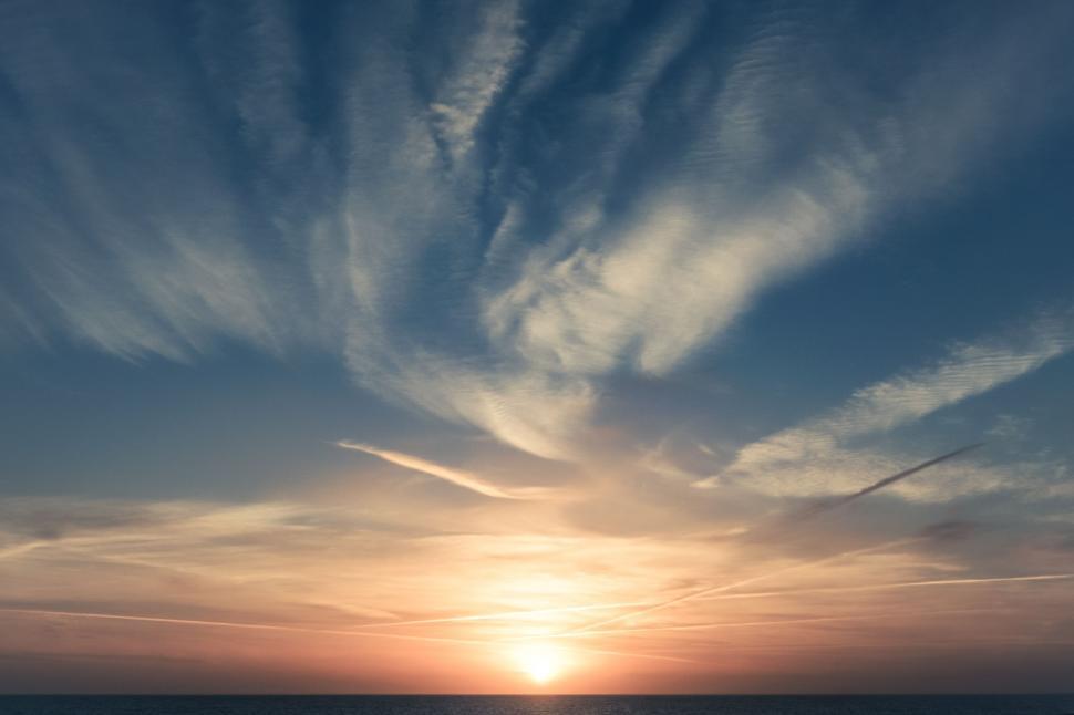 Free Image of The Sun Sets Over a Body of Water 