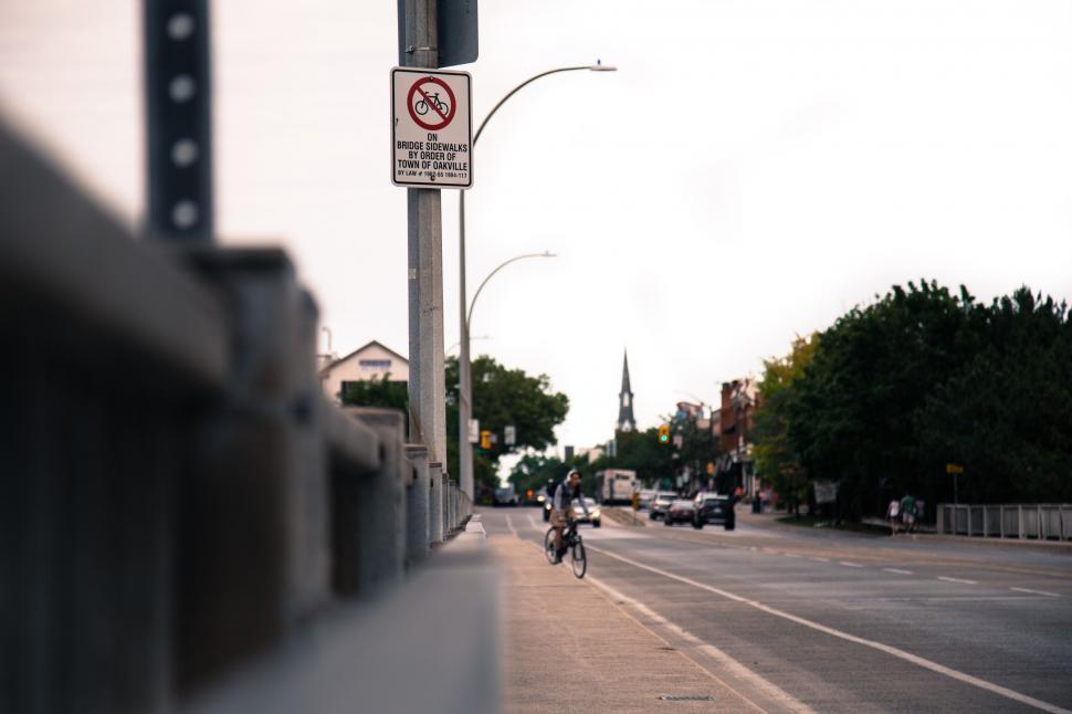 Free Image of Man Riding Motorcycle Down Street Next to Traffic Light 