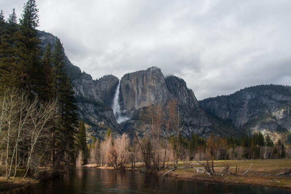 Free Image of River Flowing Through Forest Near Tall Mountain 