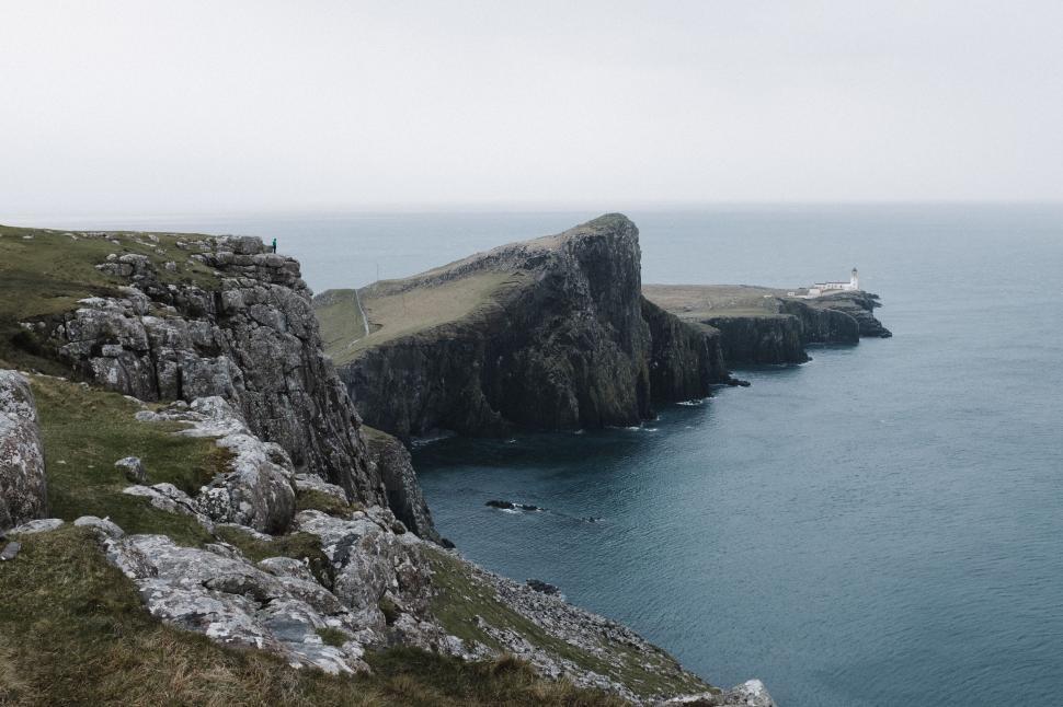 Free Image of Person Standing on Cliff by Ocean 